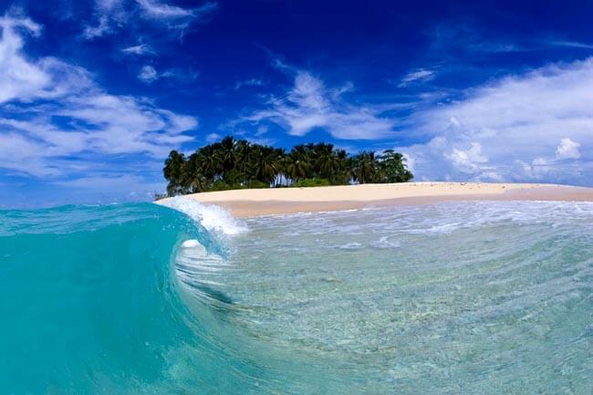 A perfect wave curling onto the beach in the Mentawai Islands
